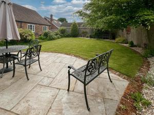 a patio with two chairs and a table with an umbrella at Lilium Cottage in North Somercotes