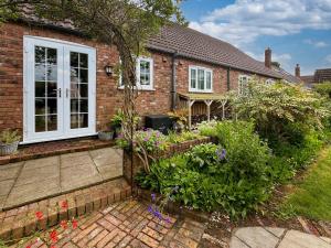 a brick house with a garden in front of it at Lilium Cottage in North Somercotes +25 photos