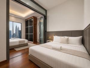 a bedroom with two beds and a large window at Royce Residence KLCC by Dormeo Destinations in Kuala Lumpur +149 photos
