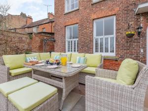 a patio with wicker chairs and a table at Bank House Apartment in Newnham