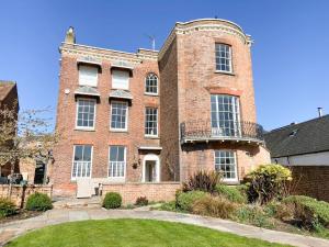 a large brick building with a yard in front of it at Bank House Apartment in Newnham