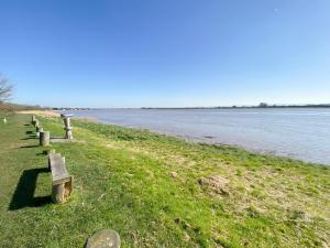 a row of benches sitting next to a body of water at Bank House Apartment in Newnham +26 photos