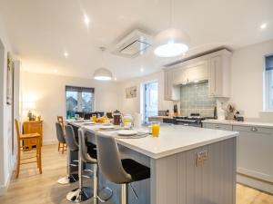a kitchen with a large island with bar stools at Walcot House Stables in Diss