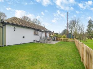 a white house with a yard and a fence at Walcot House Stables in Diss
