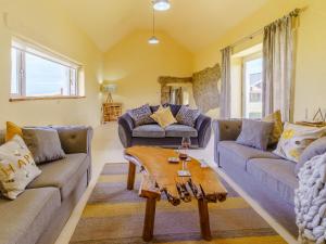 a living room with two couches and a table at The Stables - Uk32514 in Marloes