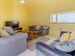 a living room with two couches and a tv at The Stables - Uk32514 in Marloes