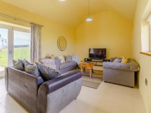 a living room with two couches and a tv at The Stables - Uk32514 in Marloes