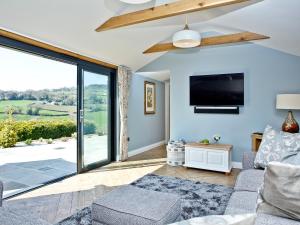 a living room with a large sliding glass door at Woodland View Lodge in Axminster