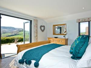 a bedroom with a bed and a large window at Woodland View Lodge in Axminster +10 photos