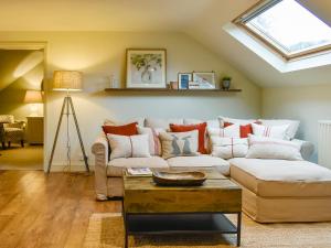 a living room with a couch and a skylight at Larkhams Loft in Teffont Magna