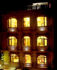 un edificio alto con ventanas iluminadas por la noche en Hotel Rivera Palace, en Varanasi