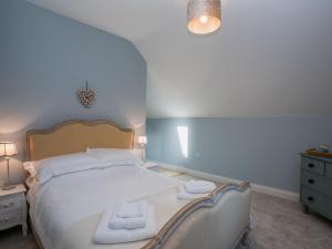 a bedroom with a bed with two towels on it at Woodcrest Barn Cottage - Ukc1065 in Shelfanger