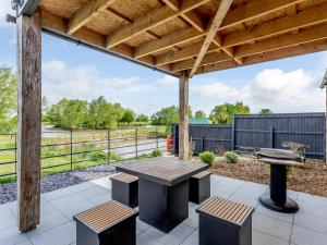 a patio with a table and benches and a fence at Home Farm Lodges in Baston
