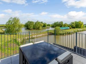 a balcony with a table and a view of a river at Home Farm Lodges in Baston