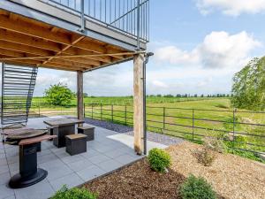 a patio with a table and benches and a view of a field at Home Farm Lodges in Baston +14 photos