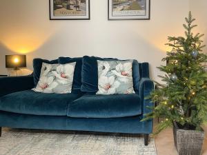 a blue couch in a living room with a christmas tree at Forest Acorn in Brockenhurst +23 photos