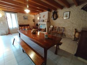 a living room with a wooden table and chairs at Le Logis de bouillé in Bouillé-Courdault