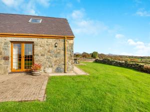 a stone house with a green lawn in front of it at Daflod - Uk48256 in Chwilog