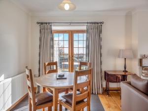 a living room with a table and chairs and a couch at Daflod - Uk48256 in Chwilog