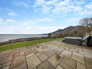 a patio with a view of the water at Y Beudy Gwydir in Trevor +19 photos