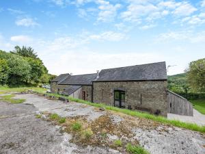 an old stone barn sits on a dirt road at Y Stabl in Llangadog