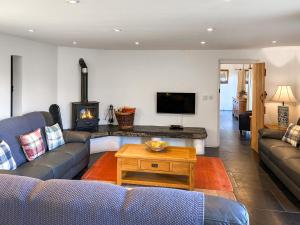 a living room with two couches and a fireplace at Y Stabl in Llangadog