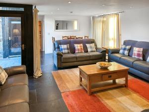 a living room with two couches and a coffee table at Y Stabl in Llangadog +17 photos