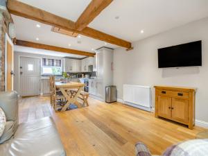 a living room with a table and a tv on the wall at The Lilac-Uk47149 in Burgh le Marsh