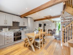 a kitchen with white cabinets and a wooden table at The Lilac-Uk47149 in Burgh le Marsh
