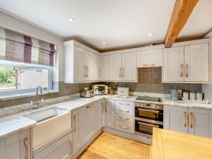 a kitchen with white cabinets and a sink at The Lilac-Uk47149 in Burgh le Marsh