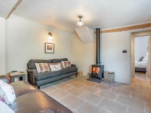 a living room with a couch and a wood stove at Queens Barn in Wortham