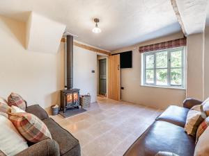 a living room with a couch and a wood stove at Queens Barn in Wortham