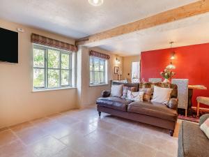 a living room with a couch and a tv at Queens Barn in Wortham