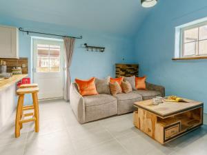 a living room with a couch and a table at The Cowshed - Uk32570 in Marloes