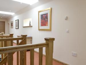 a hallway with white walls and wooden stairs at The Stables - Uk11108 in Montrose