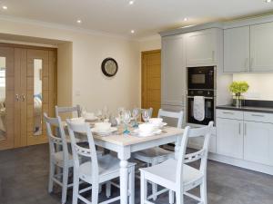 a kitchen and dining room with a white table and chairs at The Stables - Uk11108 in Montrose