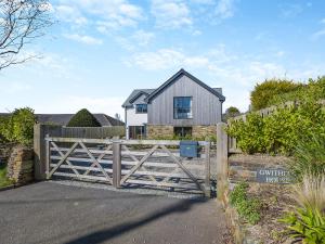 a house with a wooden gate and a fence at Gwithian House in Port Isaac