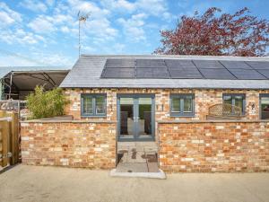 a brick house with solar panels on the roof at The Old Stables 2 - Uk46683 in Shipton under Wychwood
