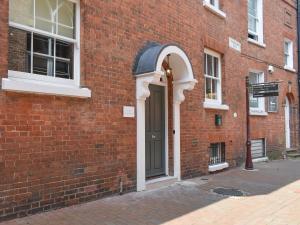 a brick building with a door and an arched doorway at The House At One Warwick Park in Royal Tunbridge Wells