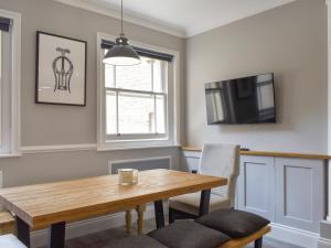 a dining room with a table and a tv at The House At One Warwick Park in Royal Tunbridge Wells