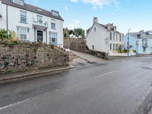 an empty street with houses and a stone wall at Beachey View - Uk43058 in Saundersfoot