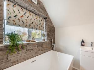 a kitchen with a window with a window curtain with birds on it at Beachey View - Uk43058 in Saundersfoot