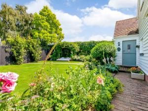 a garden with flowers and a house at Poppy's Cottage in Faversham