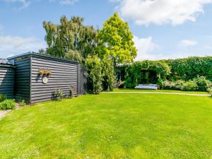 a yard with a shed and green grass at Poppy's Cottage in Faversham