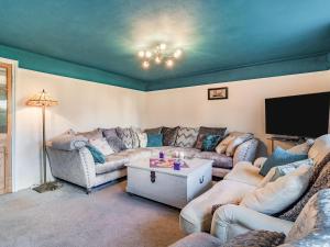 a living room with couches and a flat screen tv at Horseshoes House in Watton