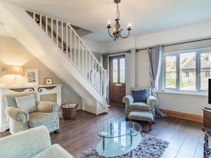 a living room with stairs and chairs and a glass table at Horseshoes House in Watton +36 photos