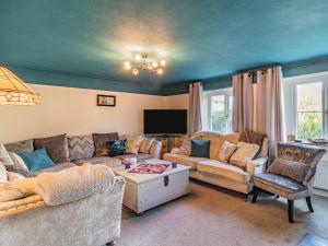 a living room with two couches and a tv at Horseshoes House in Watton