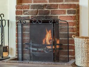 a fireplace with a roaring fire in it at Horseshoes House in Watton