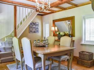 a dining room with a wooden table and chairs at Greenbank Cottage in Burley
