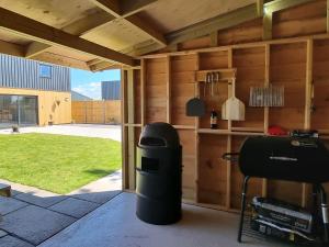 a room with a patio with a grill and a yard at Dronefield Lodge in Pitney